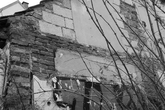 Die Struktur an der Wand des Nachbarhauses zeigt noch einen Schnitt durch das eingestürzte Haus.