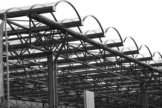 a part of an extended canopy which is in front of the greater part of the faade of a car dealership
