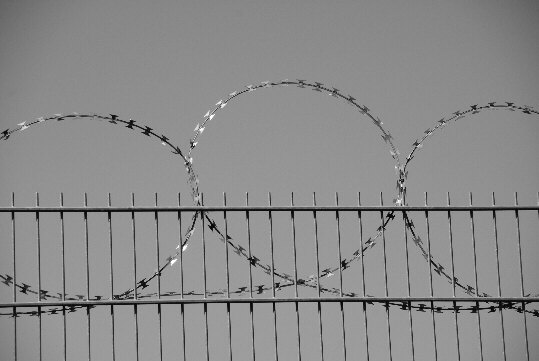 Razor barb wire at the top of a building site fence