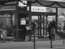 Eine junge Frau aus Rumänien spielt vor einem Verbrauchermarkt Akkordeon.