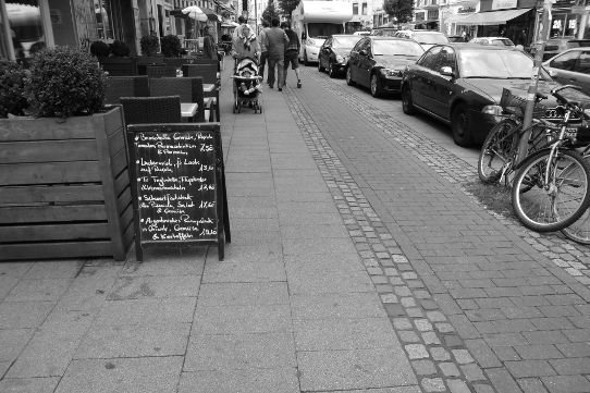 Tische und Werbeschild auf dem Bürgersteig im Viertel in Bremen