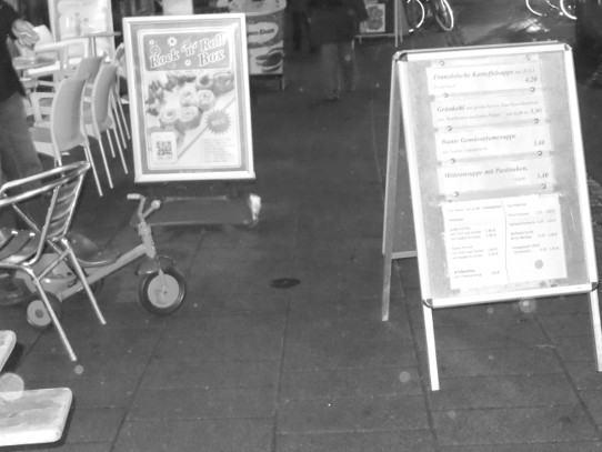 Tische und Werbeschild auf dem Bürgersteig im Viertel in Bremen