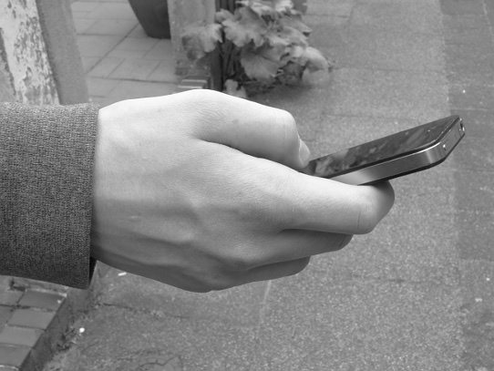 eine Hand hält Mobilfunkgerät