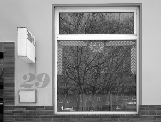 Mai 2016: Bäume und Häuser spiegeln sich im Fenster eines Schaufensters