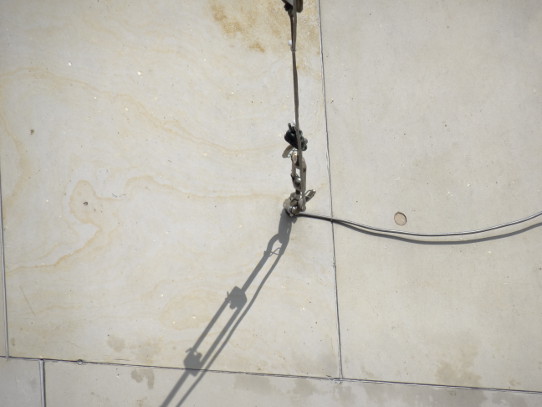Schatten von Stahlseilen auf einer Mauer