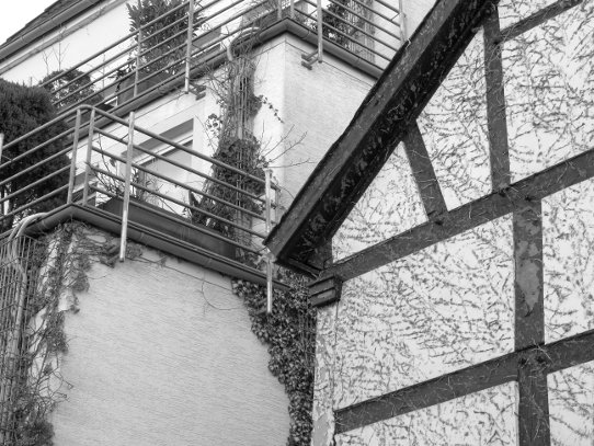Unna: Modernes Wohnhaus mit terrassierten Balkonen hinter einem alten Fachwerkhaus