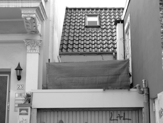 Bremen, 'Viertel': Das Bild zeigt eine 'Lücke' zwischen zwei Häusern, die mit Garage und Dachterrasse bebeut ist