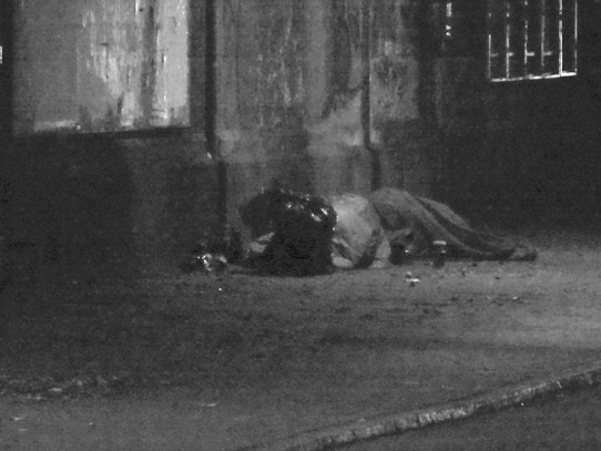 Obdachlose schlafen auf dem Fußweg unter einer Eisenbahnbrücke